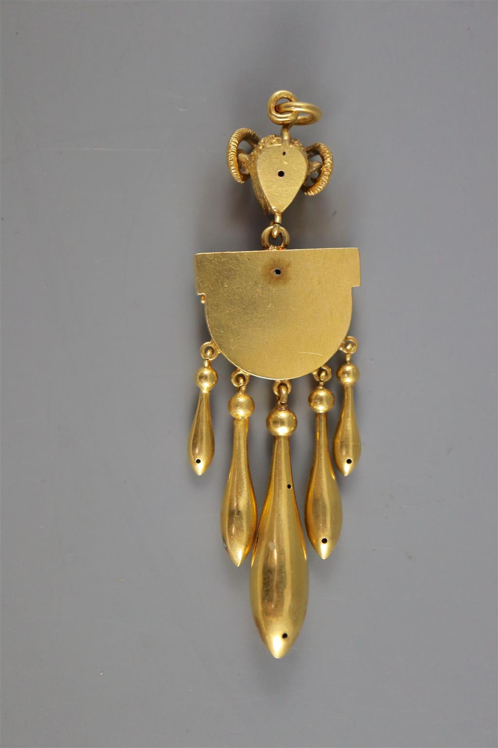 A Victorian Etruscan style gold, demi-lune and graduated five pear shaped drop pendant, with rams head bale,